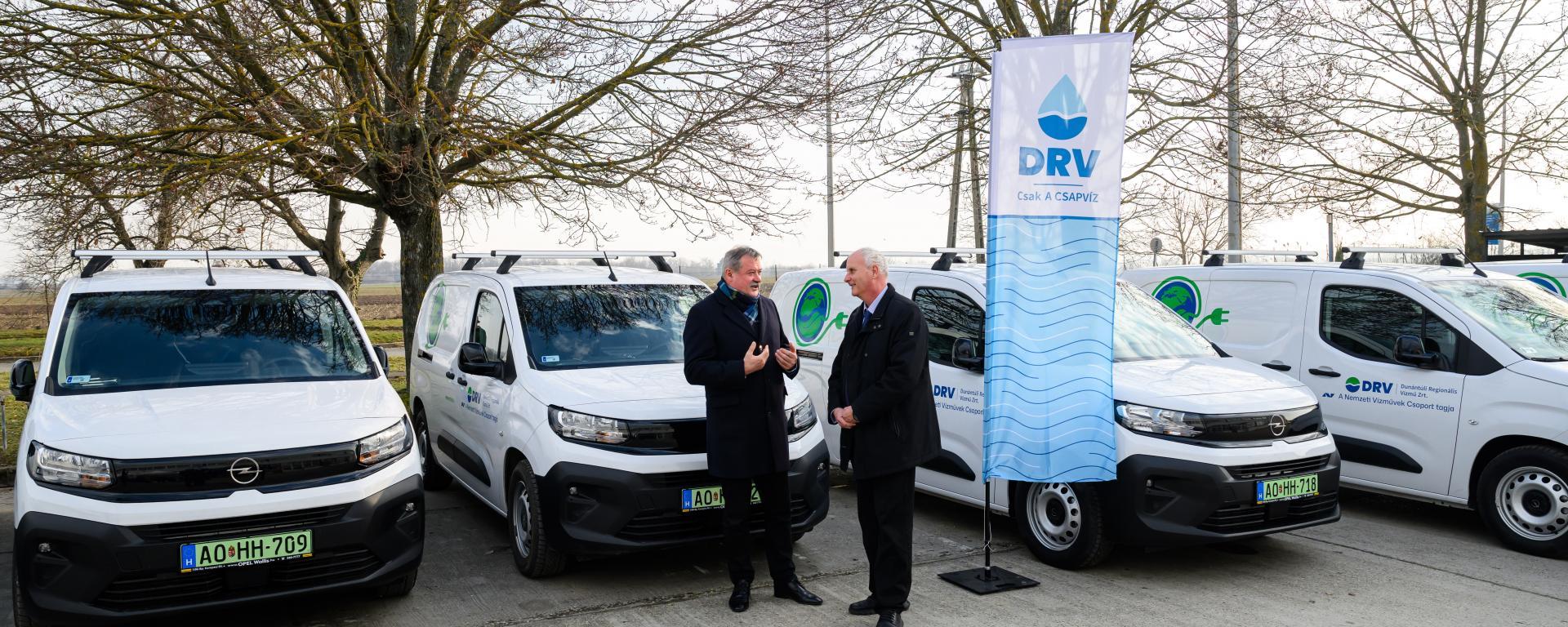 V. Németh Zsolt, az Energiaügyi Minisztérium víziközmű-ágazatért felelős államtitkára (b) és Pelcz Gábor, a Dunántúli Regionális Vízmű Zrt. (DRV Zrt.) vezérigazgatója új elektromos kishaszongépjárművek átadásán a DRV zamárdi telephelyén 2026. március 4-én. A vállalat tizenhat elektromos autót vásárolt 200 millió forintos beruházással.